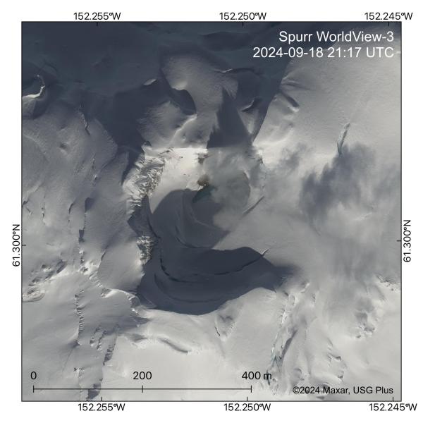 High-resolution satellite image from 18 Sep 2024 of the water lake within the summit crater of Mount Spurr. This lake formed this spring and in this image has a diameter of around 85 meters and an area of approximately 1.4 acres. The lake is partially covered by ice and is blue-green in color. Active steaming from summit area steam vents called fumaroles is visible along and above the snow-free northeastern lake shore and crater wall, and from a pit in the ice on the northeast crater rim. 