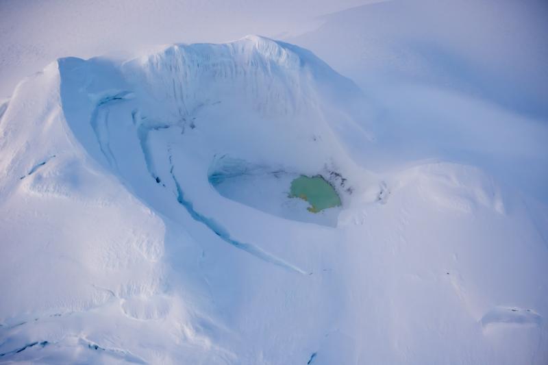 Summit and summit crater of Mount Spurr with a partially ice-covered crater lake on December 18, 2024. Photo taken part of a photo and gas survey following recent seismic unrest at the volcano.