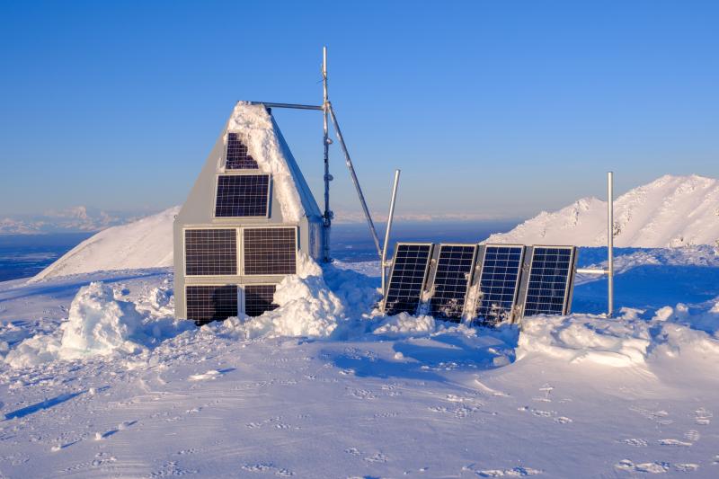 AVO geophysics station SSN on Mount Susitna on February 7, 2025, freshly cleared of ice and snow. AVO field crews visited the site to remove rim ice from solar panels to improve charging and install alternate satellite telemetry to improve data flow from the Spurr volcano network.