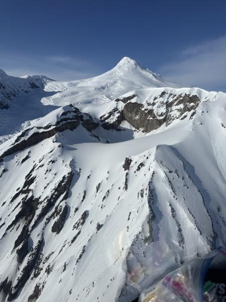 Overflight photograph showing Crater Peak in the foreground and Mount Spurr in the background on March 30, 2025.  View is looking north.  Photo credit to Tordrillo Mountain Lodge.