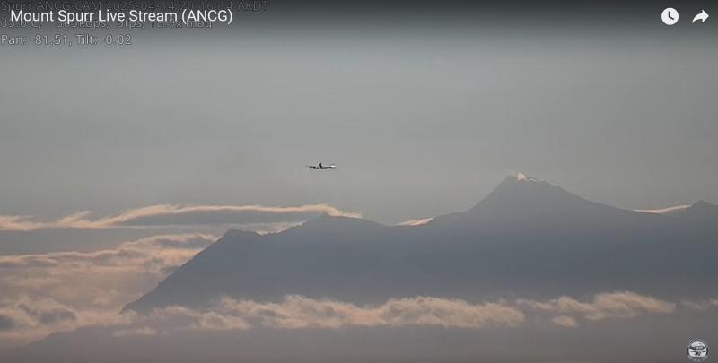 A screen capture of AVO's livestreaming Mount Spurr camera, ANCG, from April 14. A little steam is visible rising from Mount Spurr summit. A plane is also in view.