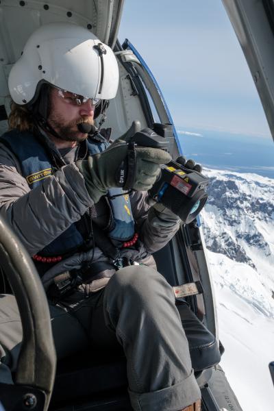 AVO geologist Jordan Lubbers taking infrared camera ("FLIR") images during an overflight of the Mount Spurr summit on June 11, 2025.