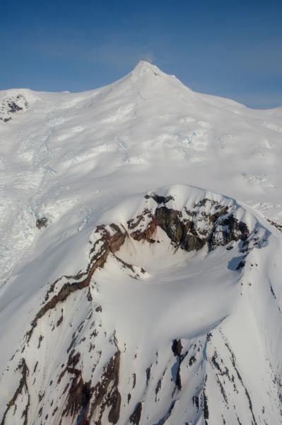Crater Peak (center) and Mount Spurr (top) during an overflight  photo and gas survey of Spurr volcano on June 11, 2025. The summit gas plume was visible drifting south towards the camera. 