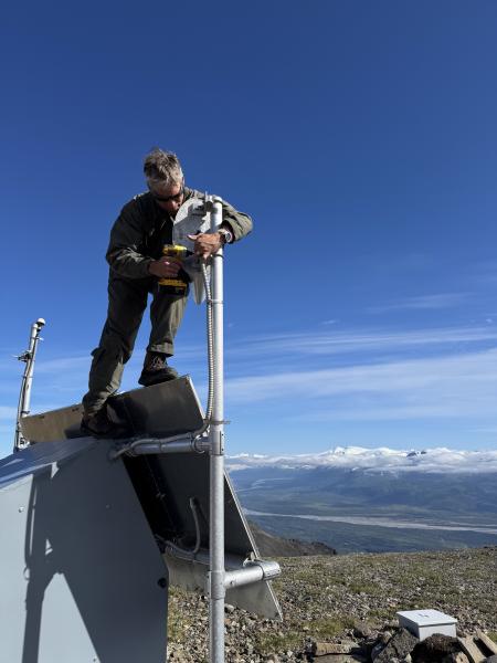 Max Kaufman installing a radome Yagi at station KAHC. Snowy Mountain is visible in the far background across the Savonoski River.