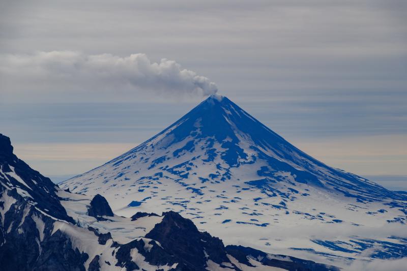 Shishaldin Volcano viewed from the summit of Roundtop Mountain on August 22, 2025. A steam and gas plume is visible drifting to the south in the image.