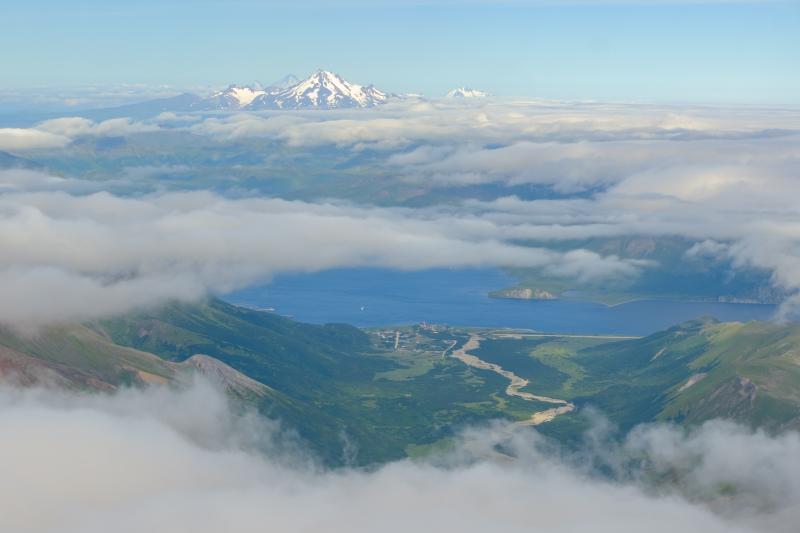 View east along the Alaska-Aleutian volcanic arc from near Roundtop Mountain. False Pass is visible in the gap below the clouds. Peaks along the horizon from right to left: Dutton, Frosty, Pavlof, Pavlof Sister. 