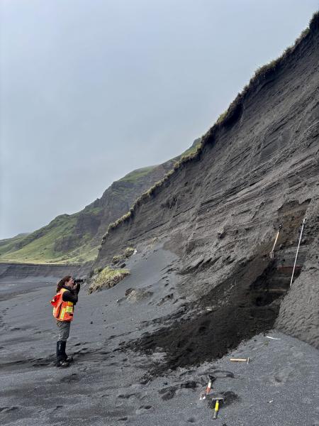 AVO geologist H. Dietterich photographing the tephra section at station 25AAHD012.
