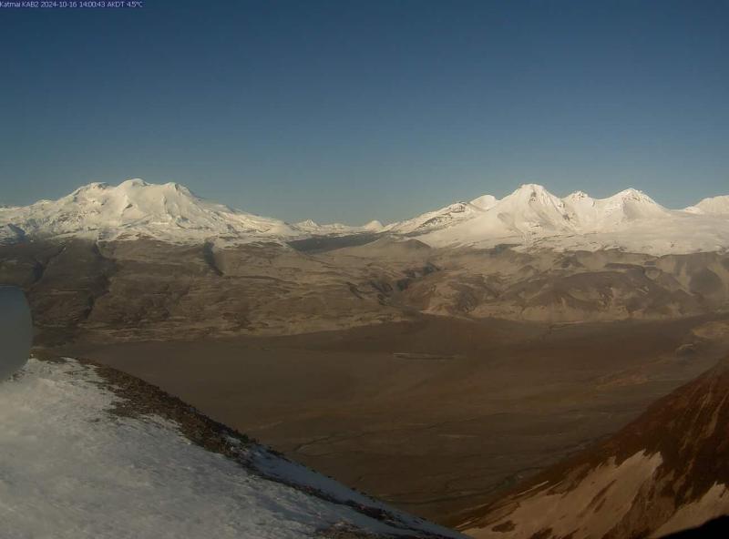 KAB2 webcam image from October 16, 2024, looking northwest across the Katmai River valley on a clear day. Trident Volcano (right) and Mount Mageik (left) form the skyline in the background.