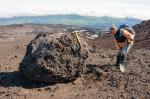 AVO geologist Pavel Izbekov examinging a large lava block on the surface of proximal pyroclastic flow deposits on the northeast flank of Shishaldin.