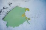 Summit crater of Mount Spurr with a partially ice-covered crater lake on December 18, 2024. Yellow sulfur precipitates are visible floating on the surface. Photo taken during a photo and gas survey following recent seismic unrest at the volcano.